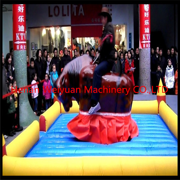 Giant Mechanical Rodeo Bull With Inflatable Mattress Interactive Game In Amusement Park